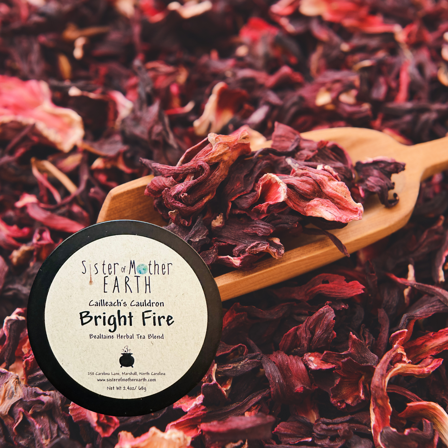Dried hibiscus petals on a wooden spoon with the Sister Mother Earth Bright Fire herbal tea label superimposed.